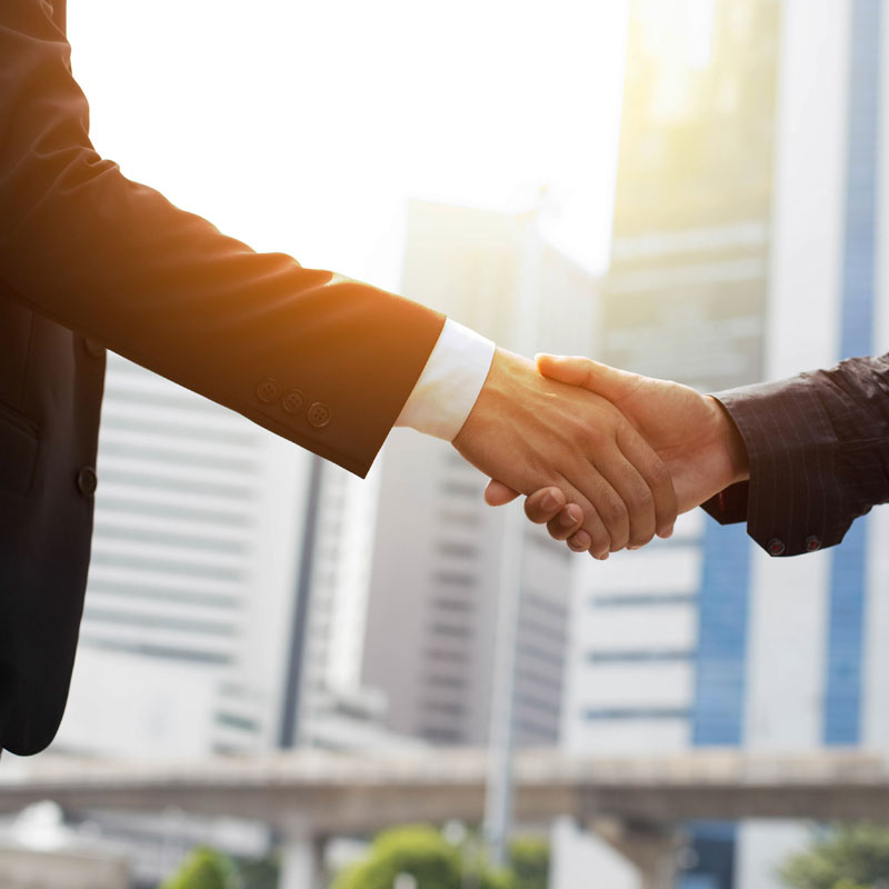 Experienced commercial real estate professionals shake hands on deal