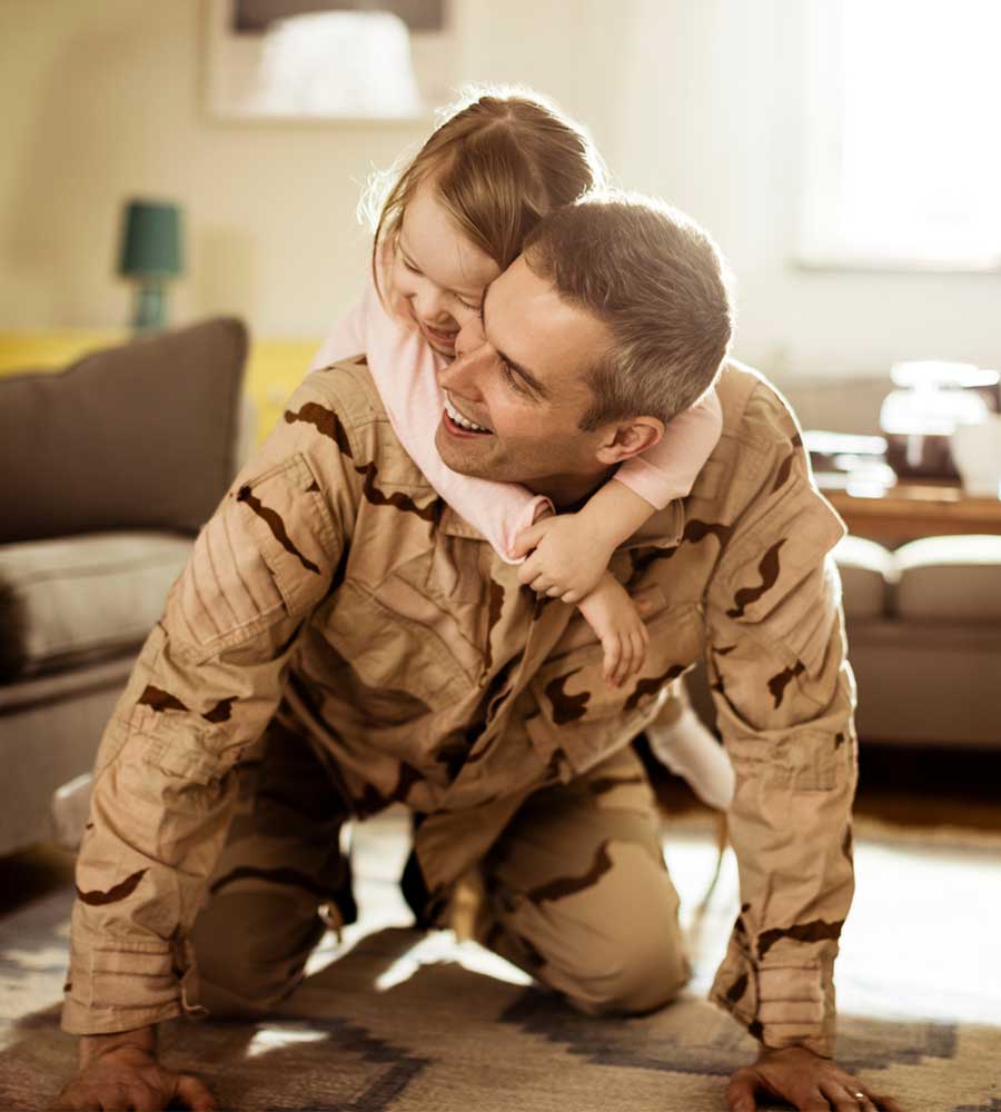 Photo of American soldier playing with his daughter at home
